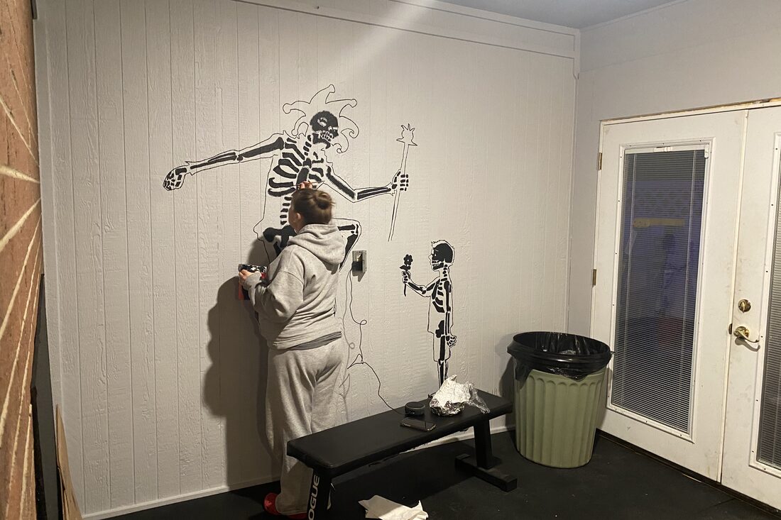 Painting a skeleton mural on the garage wall