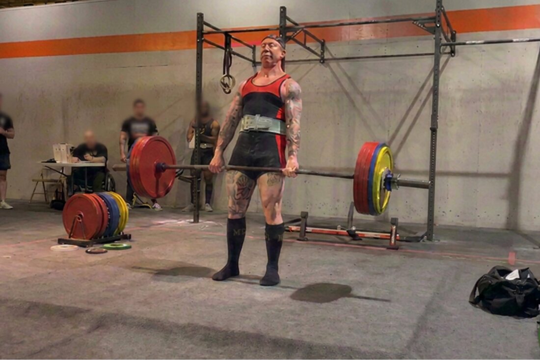 Mike locking out a heavy deadlift at a powerlifting meet